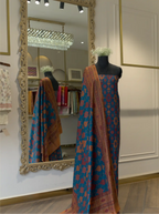 Unstitched Pure Boski Silk Teal Blue suit draped on a mannequin displaying the geometric mosaic print and draped matching printed dupatta in a store setting
