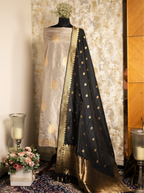 Mannequin wearing a beige Pure Kadwa Katan Silk suit paired with an elegant black and gold zari-bordered dupatta.