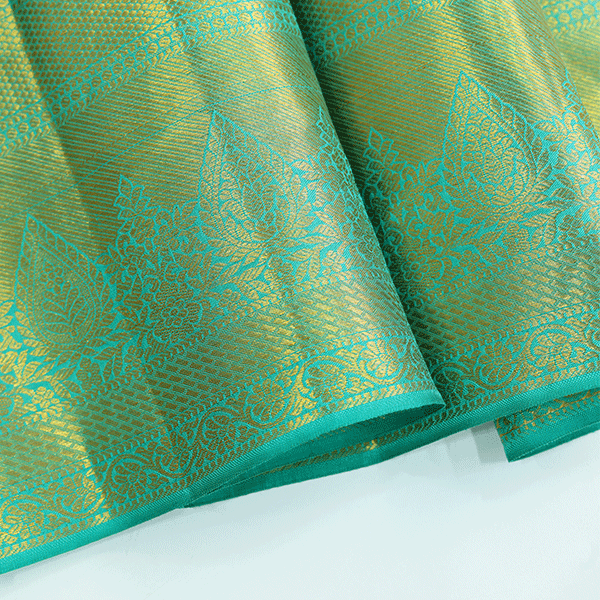 Macro shot of the pure Kanjivaram silk saree fabric, detailing the rich green and blue weave texture and authentic metallic zari craftsmanship.