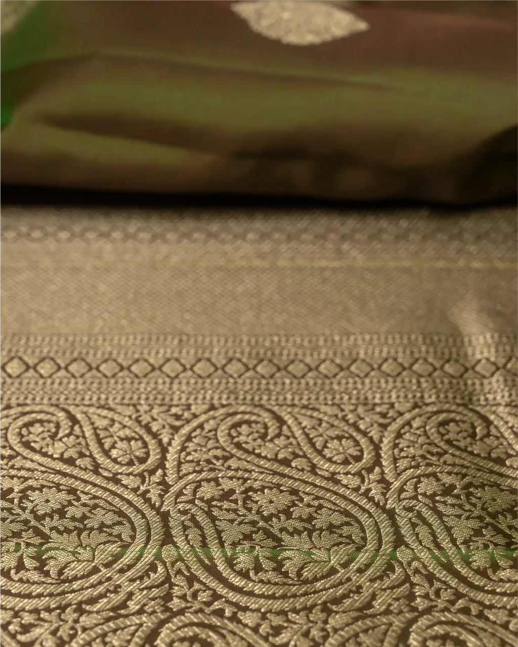 Detail shot showing the luxurious natural sheen and texture of the olive green pure silk fabric