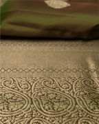 Detail shot showing the luxurious natural sheen and texture of the olive green pure silk fabric