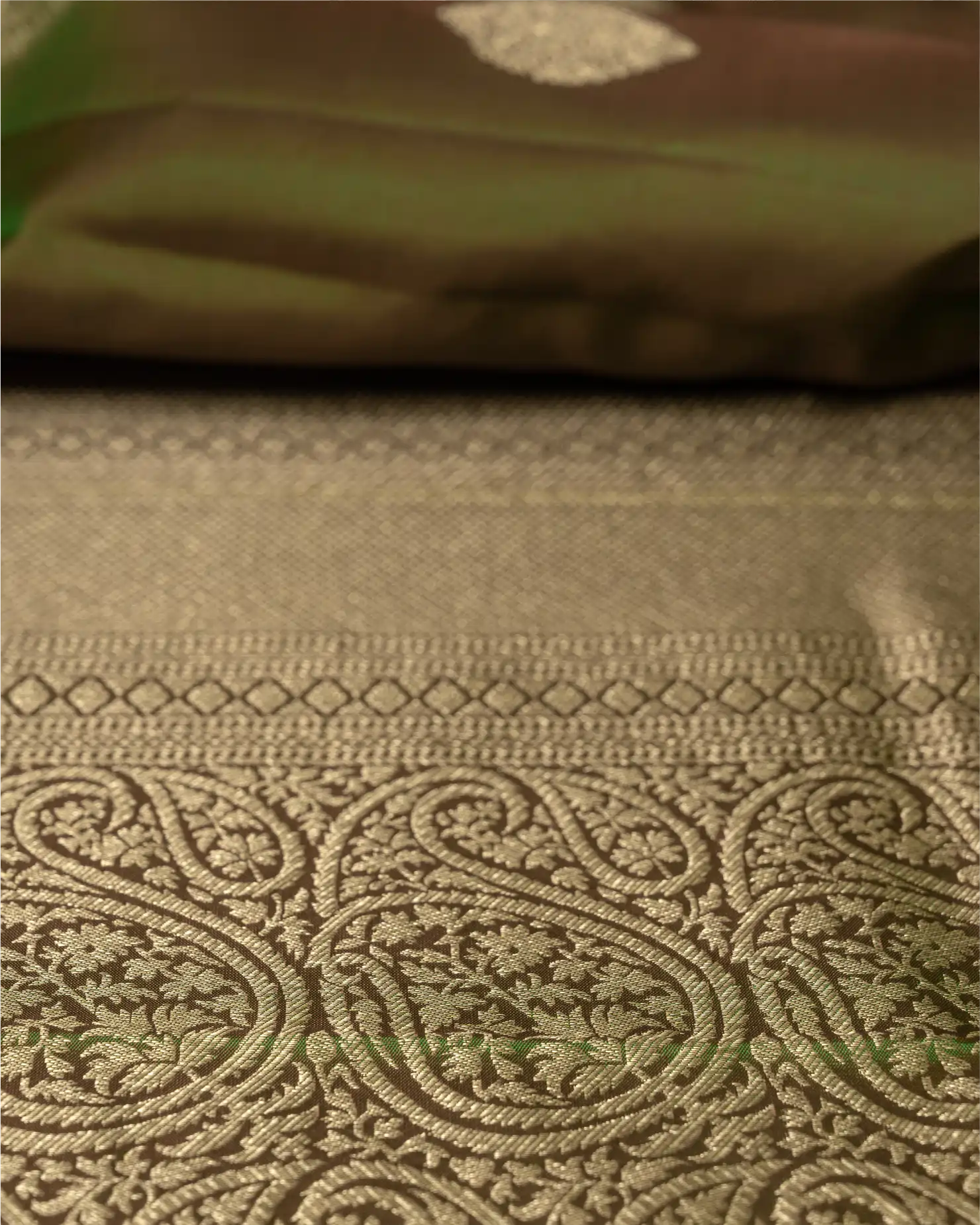 Detail shot showing the luxurious natural sheen and texture of the olive green pure silk fabric