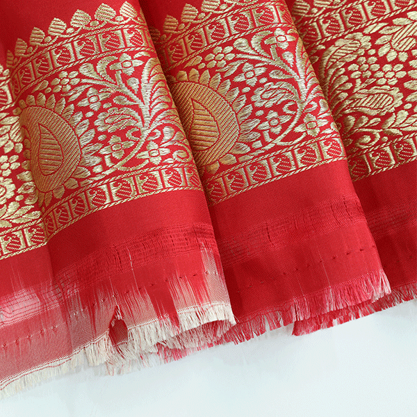 Detailed look at the matching pure silk unstitched blouse material, featuring a traditional woven gold border designed to complement the heavy Banarasi saree.