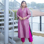 Model posing in a Royal Purple Handwoven Brocade Achkan suit, highlighting the rich gold zari floral patterns and the elegant fall of the long silk tunic.