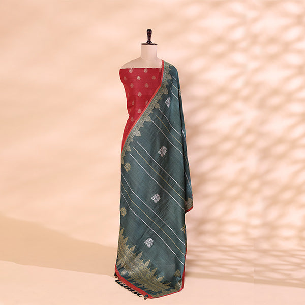 A mannequin displaying a unstitched radiant rose pink Tussar silk suit paired with an elegant draped fog grey heavy Zari dupatta against a textured background.