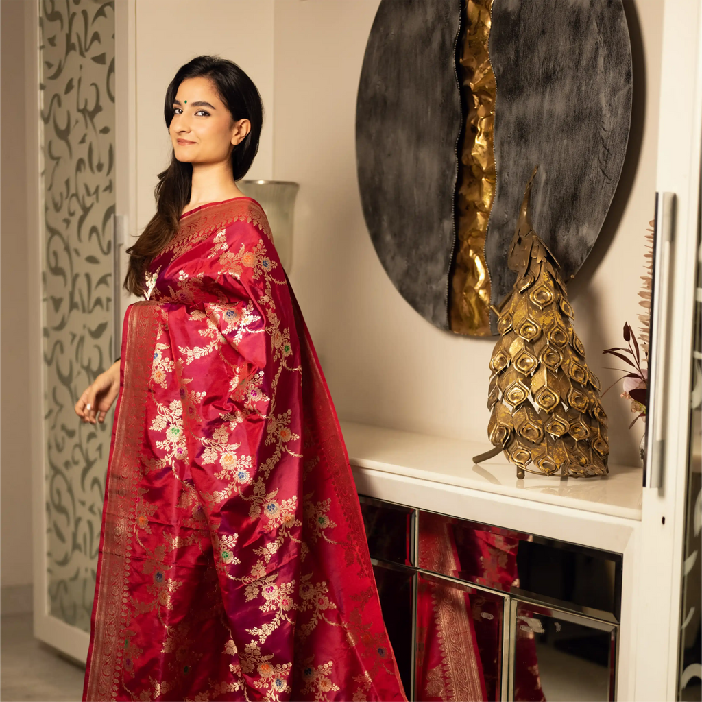 Full view of a model wearing a Red Handwoven Katan Silk Saree with gold zari floral buta and a traditional border from Arzo India.