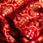 Close-up of handwoven Nilambari Iktara silk fabric featuring a mixture of gold and silver zari motifs in a traditional geometric floral pattern