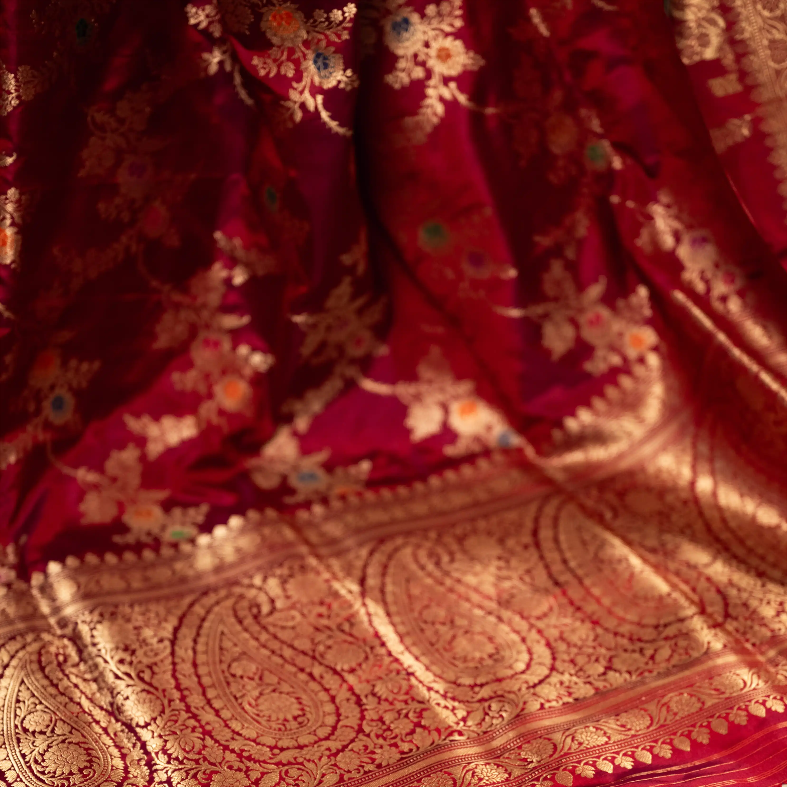 Close-up of the intricate gold zari border and floral paisley motifs on a Red Handwoven Katan Silk Saree from Arzo India.