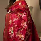 Side view of a premium Red Handwoven Katan Silk Saree highlighting the intricate gold zari pallu with colorful floral and paisley embroidery.