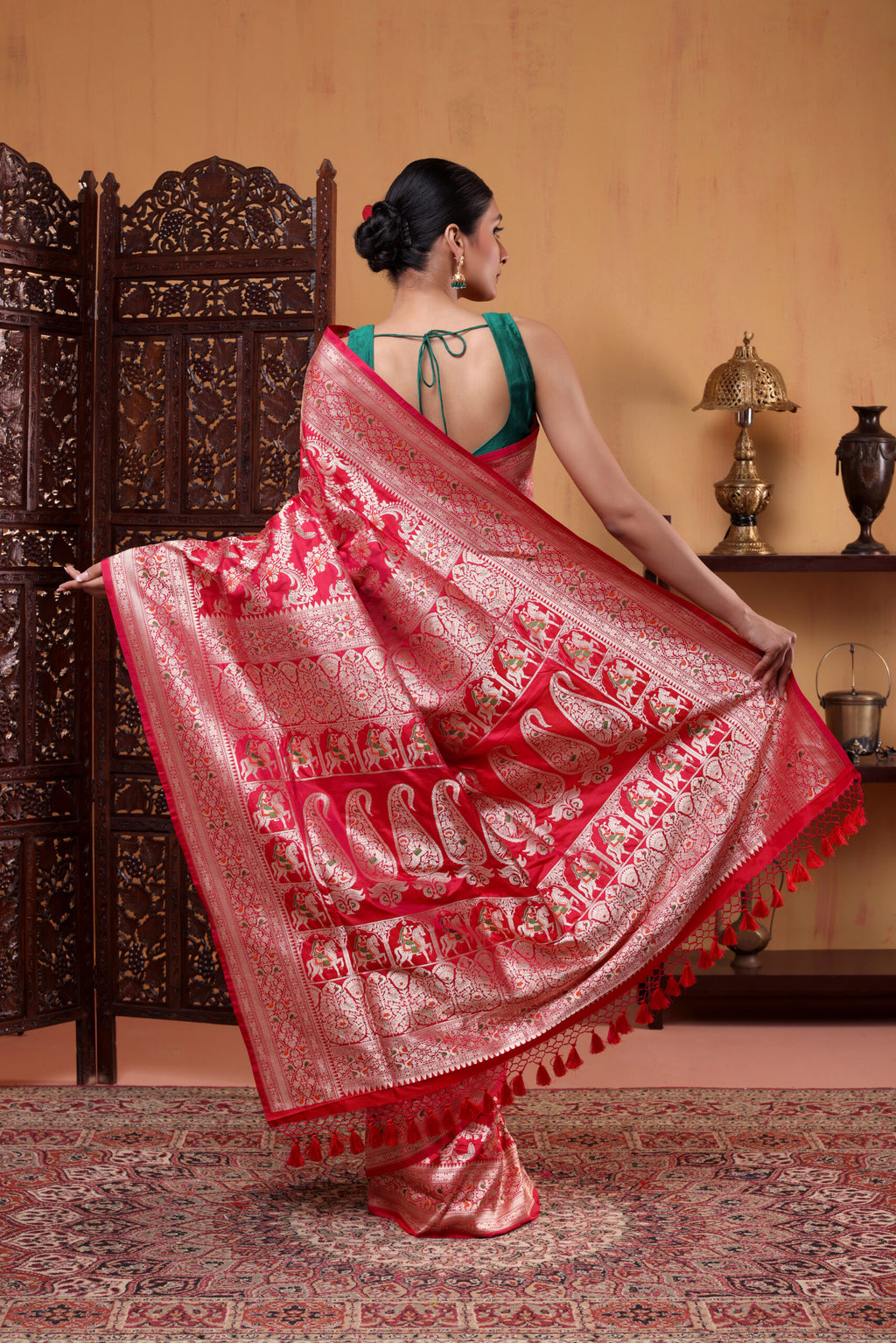 Full-length view of the crimson red pure Katan silk saree highlighting the luxury handwoven Banarasi Shikargah motifs along the pleats and border.