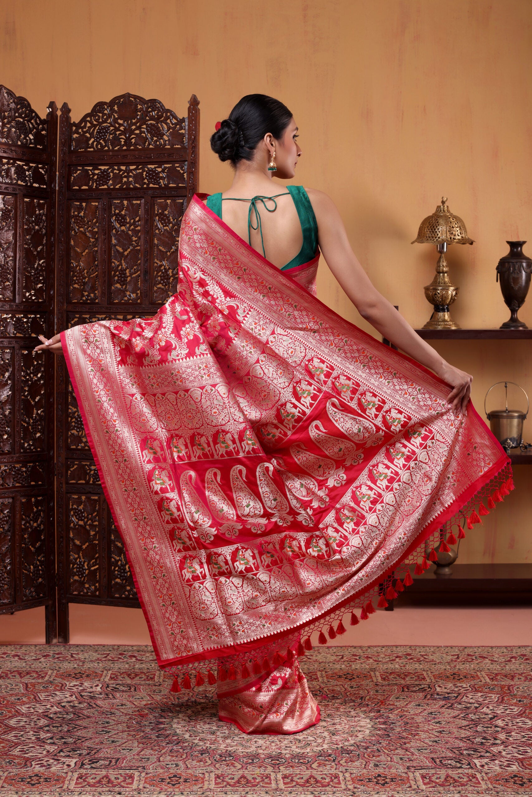 Full-length view of the crimson red pure Katan silk saree highlighting the luxury handwoven Banarasi Shikargah motifs along the pleats and border.