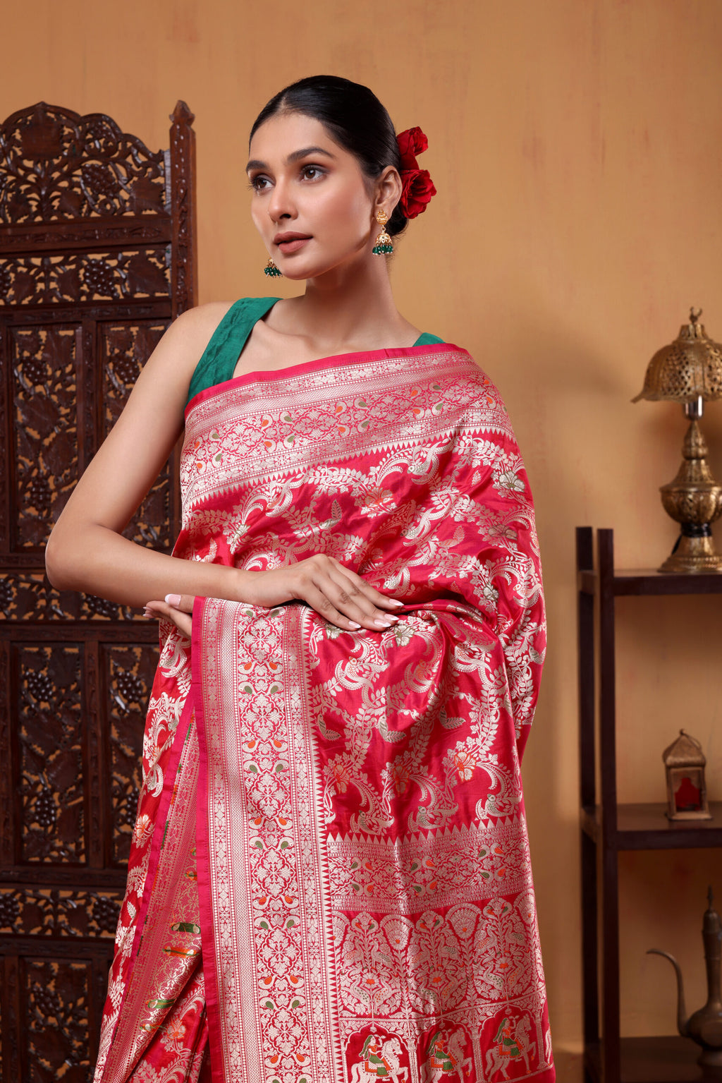 A elegant model draped in the Regal Crimson Shikargah Katan Silk Saree, showcasing the rich crimson red body, Meenakari four-sided border, and intricate handwoven patterns.