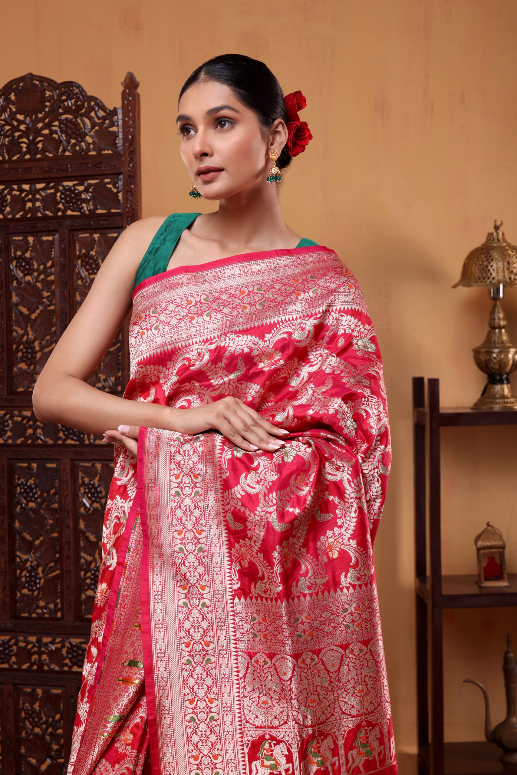 A elegant model draped in the Regal Crimson Shikargah Katan Silk Saree, showcasing the rich crimson red body, Meenakari four-sided border, and intricate handwoven patterns.
