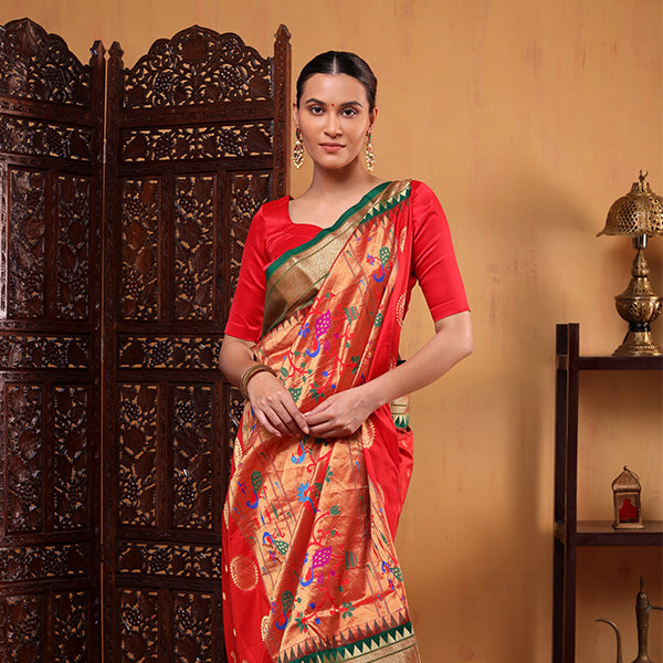 A model wearing the green and red Regal Harmony Paithani silk saree with intricate traditional handwoven motifs and a rich zari border, posing against an elegant backdrop.