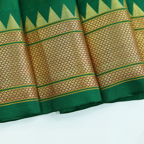 Close-up view of the unstitched green Paithani silk blouse piece fabric featuring a traditional gold zari temple border pattern.