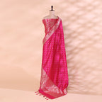 A mannequin displaying a deep pink handwoven Banarasi silk suit set featuring an intricate gold Zari pattern and a matching Meena detailing dupatta.