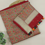 A beautiful flat-lay of a rich red handwoven Banarasi silk suit set, featuring intricate floral patterns, premium zari border detailing, and a coordinating contrast dupatta with traditional tassels.