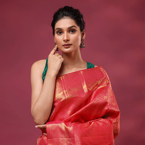 Full-length view of the pink magenta Kanjivaram silk wedding saree showcasing the traditional gold weaving patterns along the pleats and border.