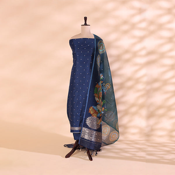 A royal blue Banarasi silk suit displayed on a mannequin, featuring intricate gold zari detailing and a vibrant floral Kalamkari patterned dupatta.