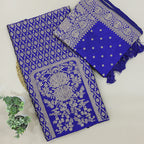 A flat-lay view of a royal blue Banarasi silk unstitched suit material featuring intricate silver zari floral motifs, paired with a matching dupatta on a neutral background.
