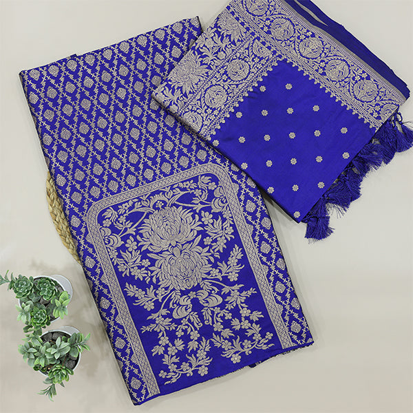 A flat-lay view of a royal blue Banarasi silk unstitched suit material featuring intricate silver zari floral motifs, paired with a matching dupatta on a neutral background.