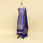 A mannequin displaying an elegant royal blue Banarasi silk suit featuring intricate silver zari work, traditional floral motifs, and a matching draped dupatta.