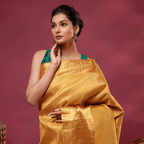 Full-length view of the luxurious golden-mustard Kanjivaram silk saree, showcasing its opulent drape and traditional handwoven structure.