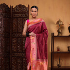 A model showcasing a royal orchid Katan silk saree featuring a detailed pink and orange sunset blush Paithani border, styled with a matching sleeveless blouse.