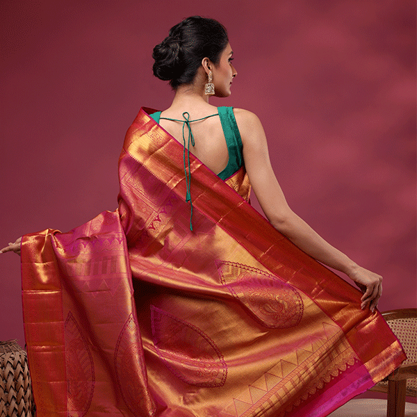 A detailed display of the luxurious heavy gold zari pallu and ornate borders of the royal plum Kanjivaram silk saree.