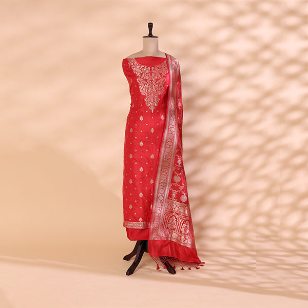 Pure handwoven Banarasi Silk unstitched suit in deep crimson displayed on a mannequin, featuring an intricate traditional full Jaal design and an elegant neck pattern.