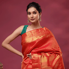 A model showcasing the elegant Scarlet Gold Kanjivaram Silk Saree, featuring vibrant red and rich golden handwoven hues with a contrasting green blouse.