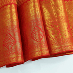 Flat lay presentation of the complete luxury Scarlet Gold Kanjivaram Silk Saree with its unstitched blouse piece, highlighting the authentic heritage craftsmanship.