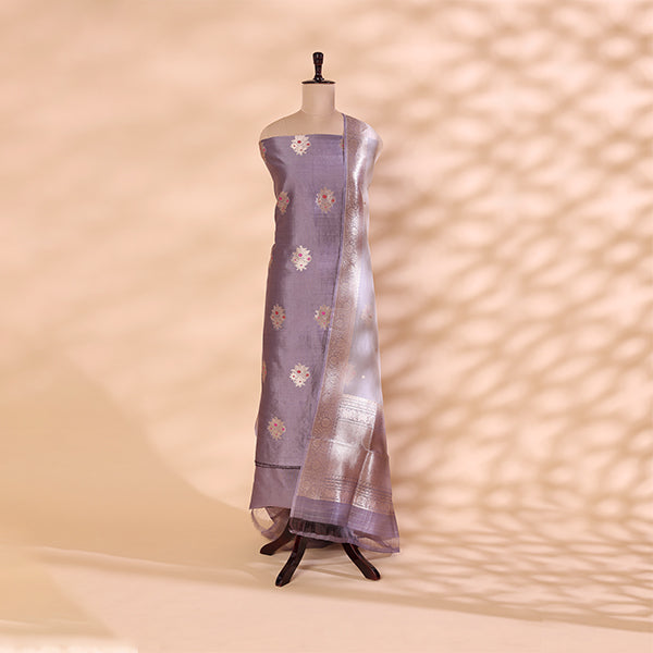 Pure handwoven Banarasi Silk unstitched suit in delicate light blue displayed on a mannequin, featuring intricate Kadhua Boota, Meena, and Zari work with a shimmering silver dupatta.