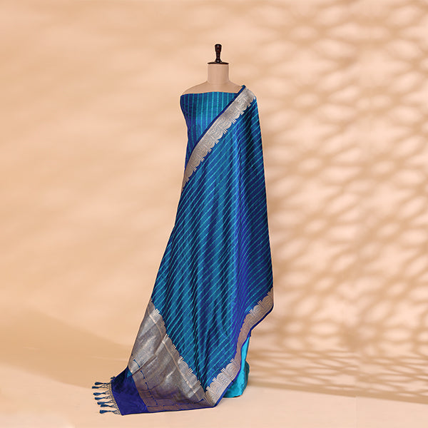 Flat lay presentation of the complete unstitched luxury suit set, showing the tranquil blue handwoven satin silk kurta fabric, matching bottom material, and silver border dupatta.