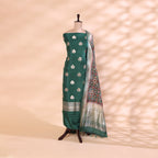 Pure handwoven Patola Silk unstitched suit featuring a serene ocean mist green base displayed on a mannequin, paired with a vibrant multicolored kaleidoscopic dupatta.
