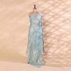 A mannequin displaying a sophisticated sky-blue Banarasi silk saree, featuring intricate gold zari floral motifs and a soft, elegant drape.