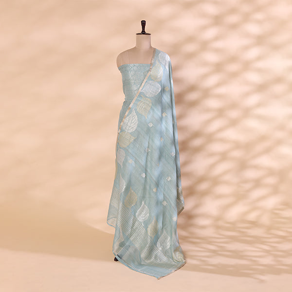 A mannequin displaying a sophisticated sky-blue Banarasi silk saree, featuring intricate gold zari floral motifs and a soft, elegant drape.