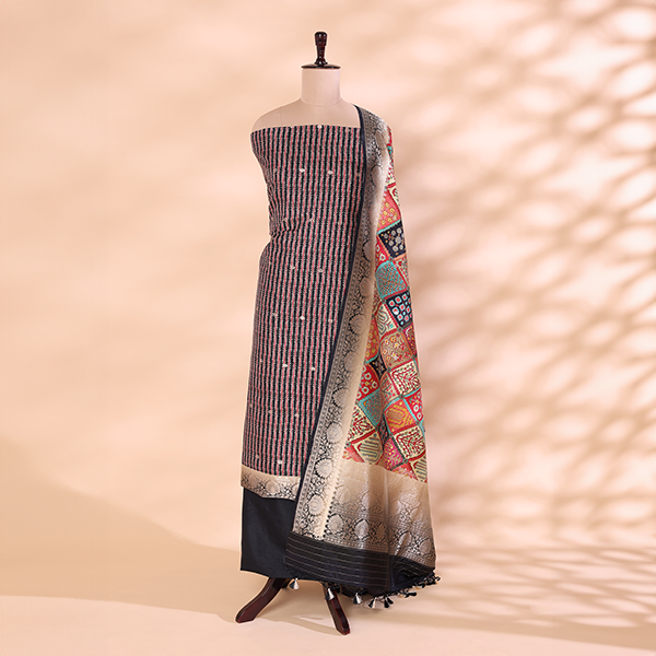 A mannequin displaying an elegant striped silk unstitched suit paired with a vibrant, multicolored traditional patchwork dupatta, featuring intricate woven borders.