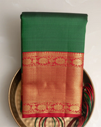 A styled look featuring the emerald green Kanjivaram silk saree paired with traditional temple jewelry.