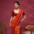 A model posing in the Sunlit Symphony pure Banarasi silk saree featuring radiant yellow and red all-over handwoven stripes, paired with a solid dark red silk blouse.
