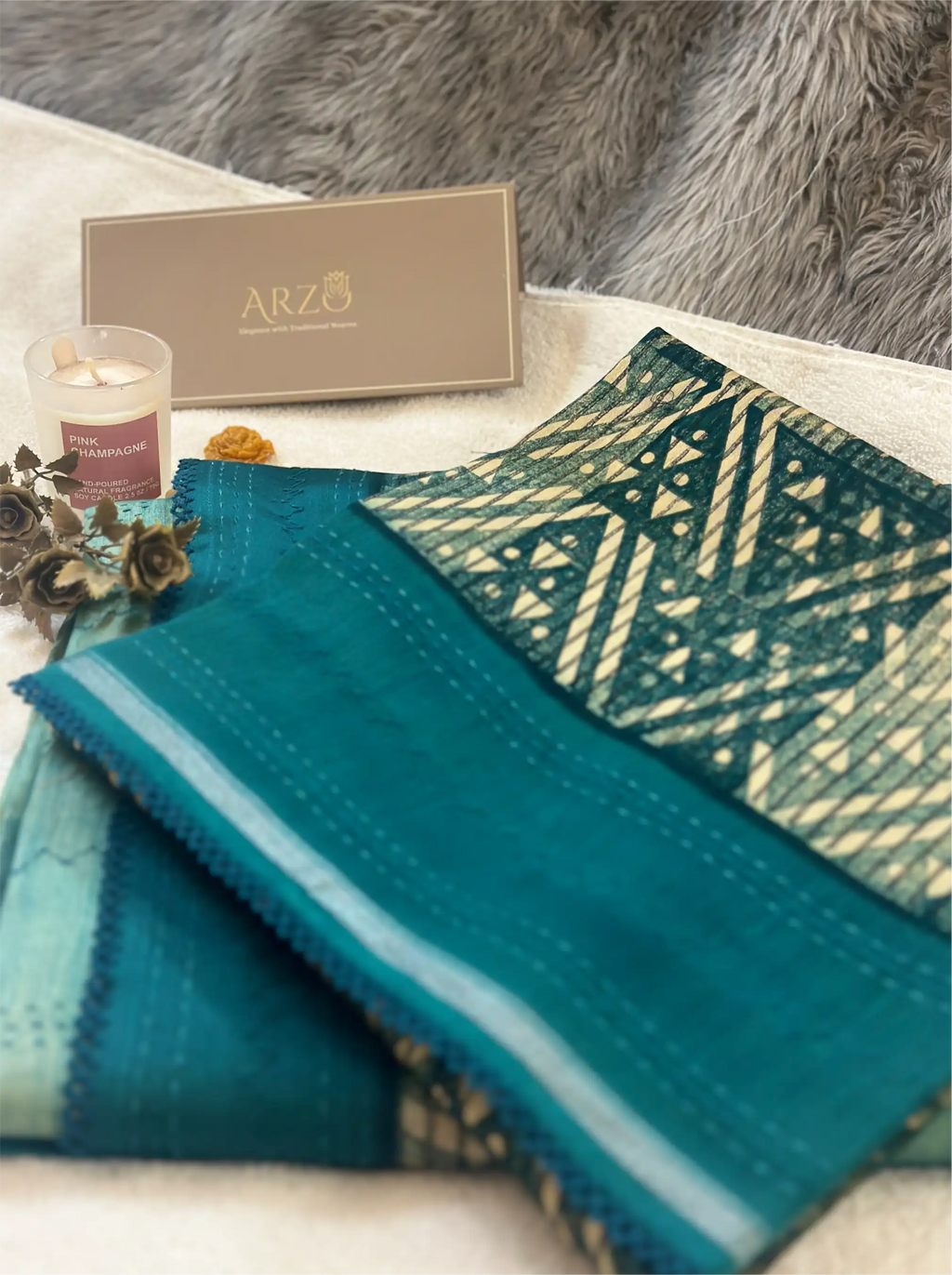 Close-up of a teal cotton fabric with an intricate geometric pattern, displayed with an ARZO branded gift box.