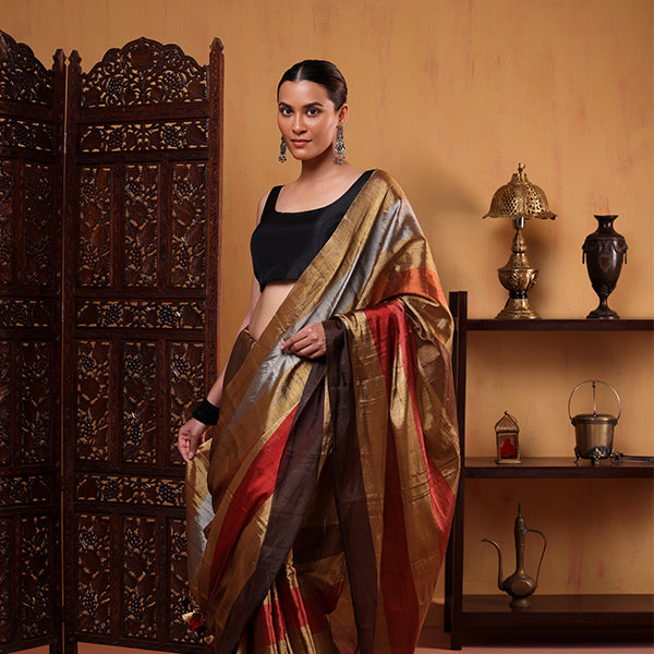 Detailed view of the pure tissue saree showcasing the intricately handwoven strips in natural, earthy tones and artisan craftsmanship.
