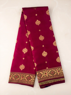 Folded handwoven Kanjivaram Paithani silk saree showcasing rich silk fabric, a wide gold zari border, and an elaborate pallu woven with intricate peacock and floral motifs in vibrant traditional colors.