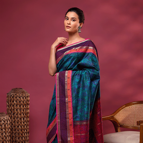 Detailed view of the Banarasi silk saree's elegant drape, showcasing the striking tri-color border contrast blending dawn pink, twilight blue, and dusky gold.