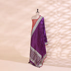 Close-up shot of the luxurious twilight amethyst pure handloom Patola Banarasi silk fabric detailing the intricate Resham and Zari weaving.