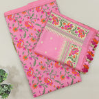 A beautiful flat-lay view of a vibrant pink handloom saree featuring intricate floral motifs and a traditional woven border with colorful tassels, displayed on a neutral background.