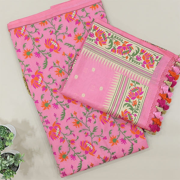 A beautiful flat-lay view of a vibrant pink handloom saree featuring intricate floral motifs and a traditional woven border with colorful tassels, displayed on a neutral background.