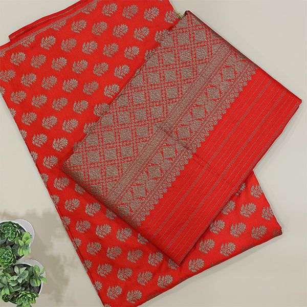 A beautiful flat-lay view of a vibrant red Banarasi silk saree featuring intricate gold zari floral motifs and a rich traditional border, displayed on a neutral background.