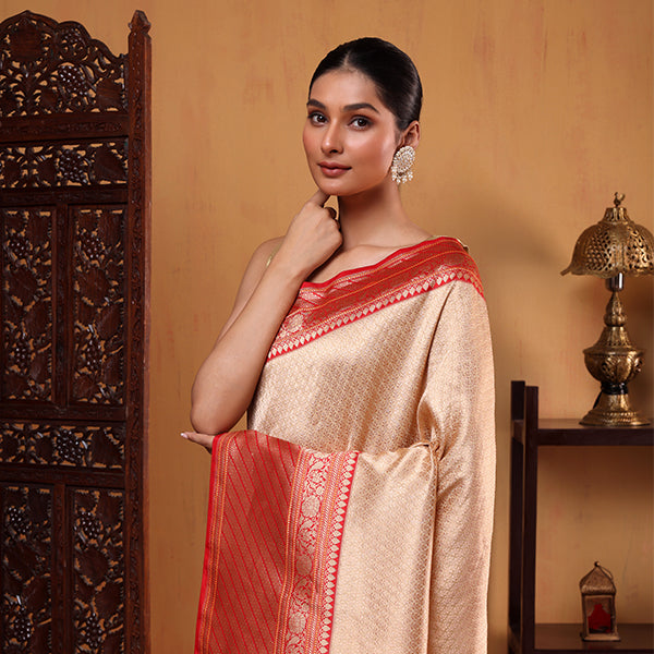 Elegant woman wearing a White Opulence Handwoven Banarasi Silk Saree with a rich red and gold zari border, featuring intricate Sona Rupa brocade work.