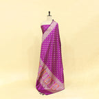 Premium wine purple Banarasi silk suit fabric paired with a matching heavy zari border dupatta on a mannequin.
